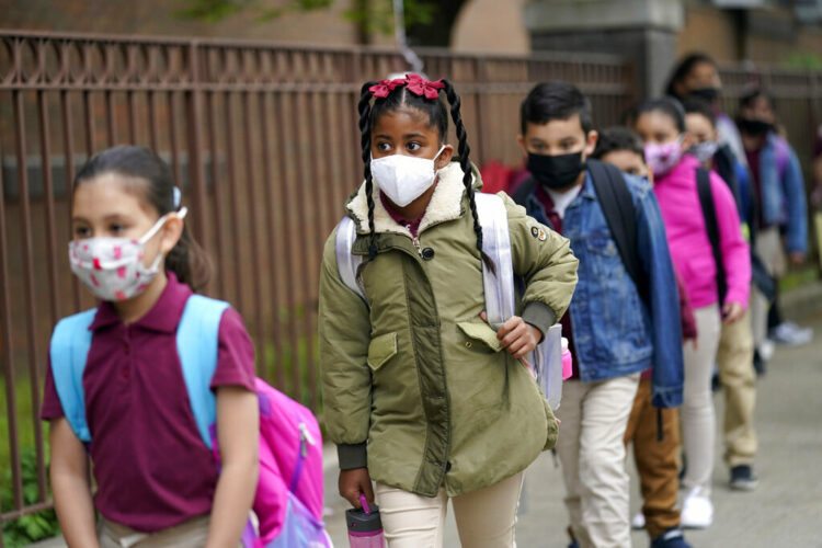 FILE - Students line up to enter Christa McAuliffe School in Jersey City, N.J., April 29, 2021. New Jersey Gov. Phil Murphy will end a statewide mask mandate to protect against COVID-19 in schools and child care centers, his office said Monday, Feb 7, 2022. (AP Photo/Seth Wenig, File)